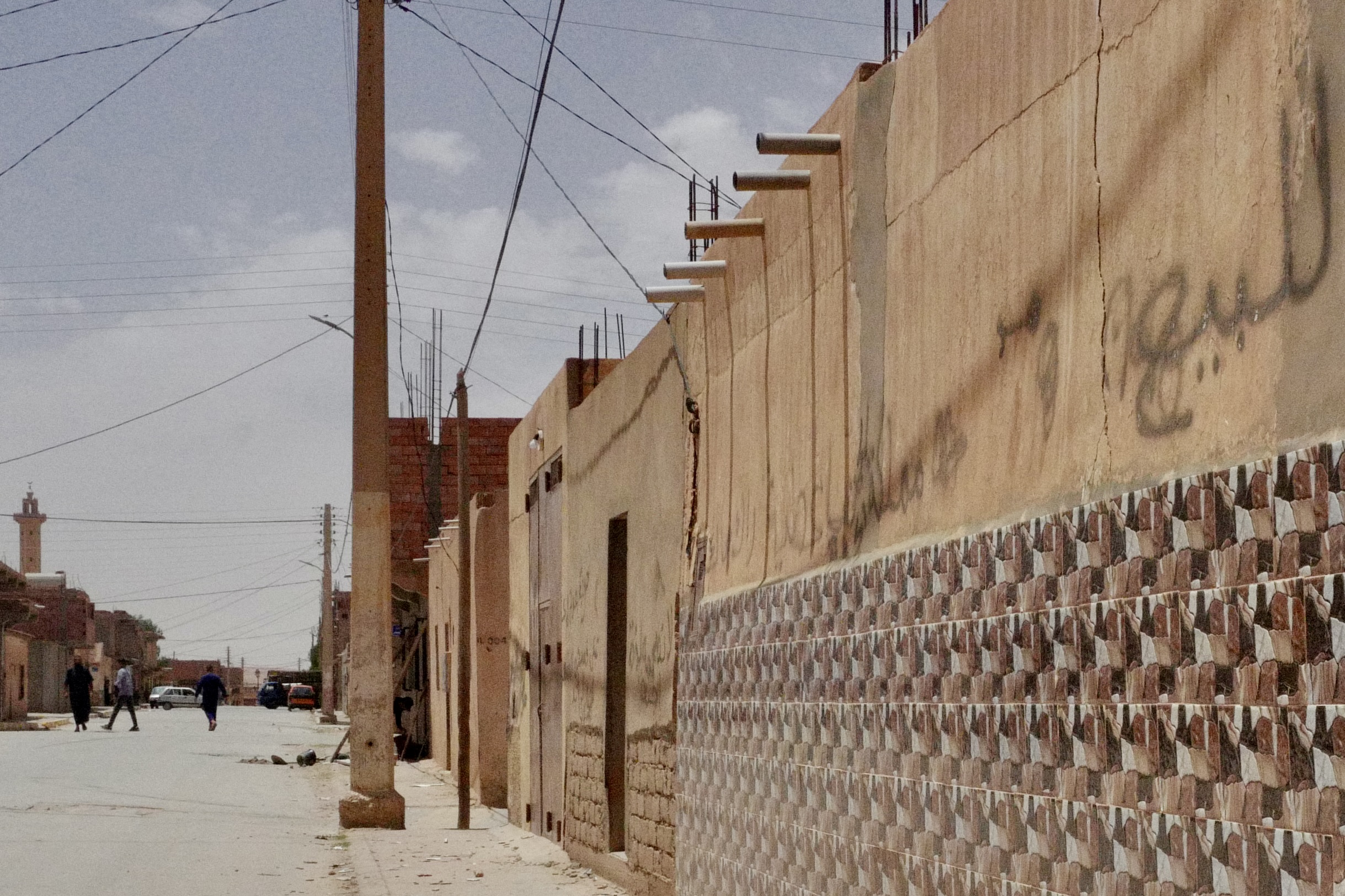 La casa del captor, cubierta de grafitis, está a solo unas puertas de la casa familiar de Bin Omran, cerca del coche rojo